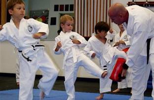 Children practicing martial arts kicks