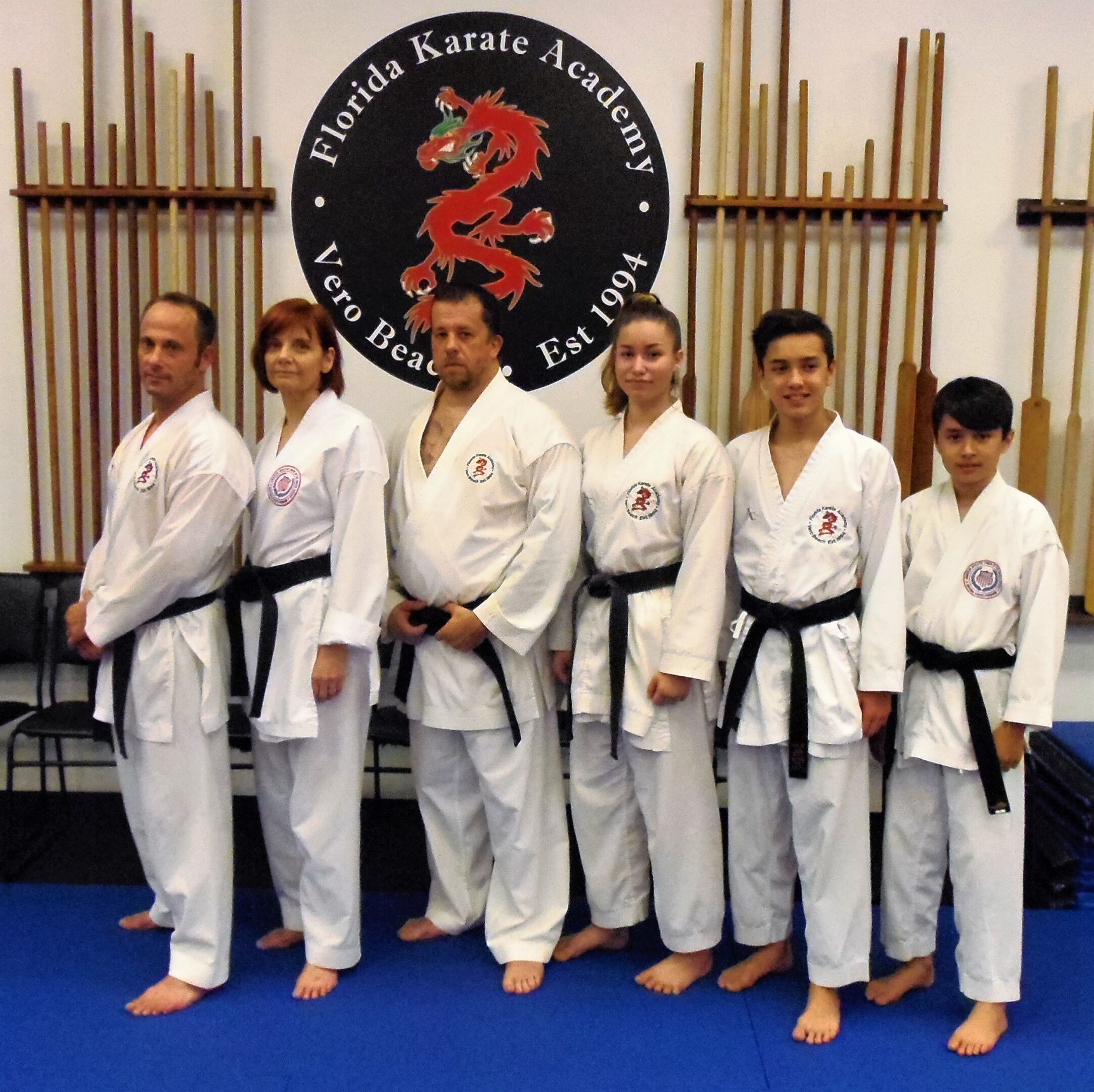 Karate students in white uniforms posing