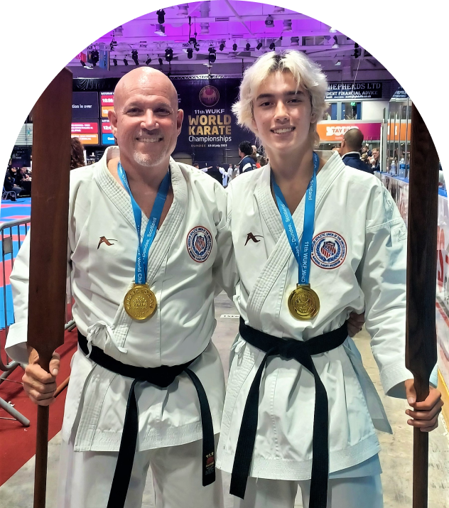 Two martial artists smiling with medals