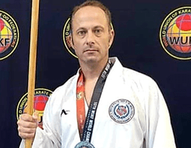 Karateka holding medal and staff